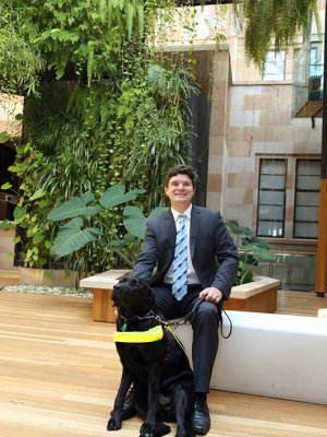 A man patting a vision assistance dog.